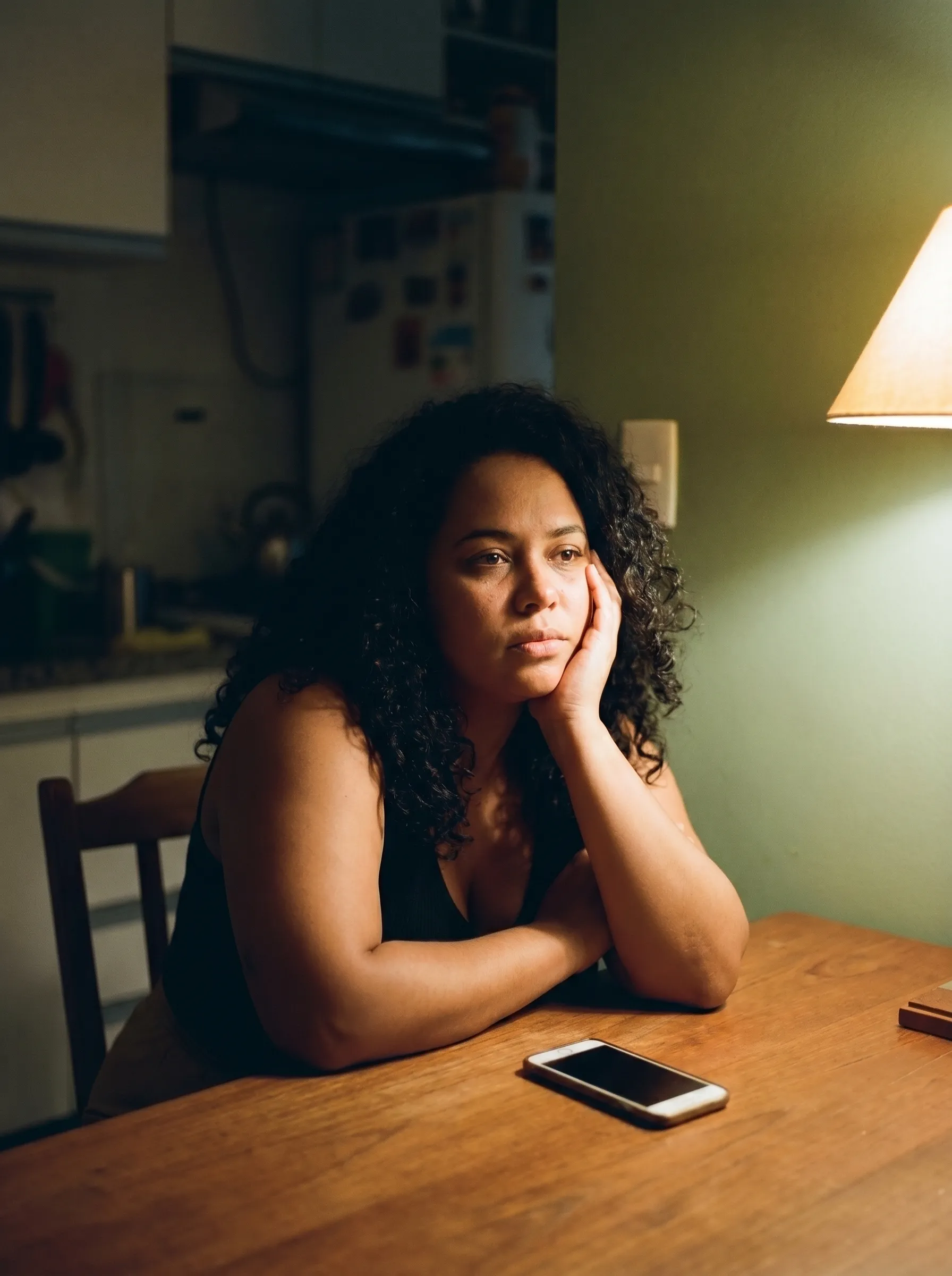 Mulher pensativa e cansada à noite na cozinha